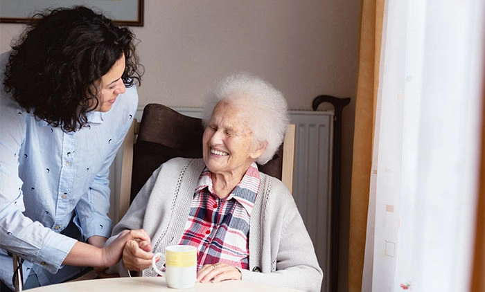 Elderly woman being assisted in her home
